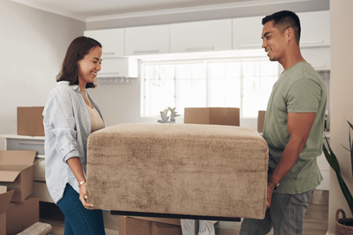young Couple moving furniture into house