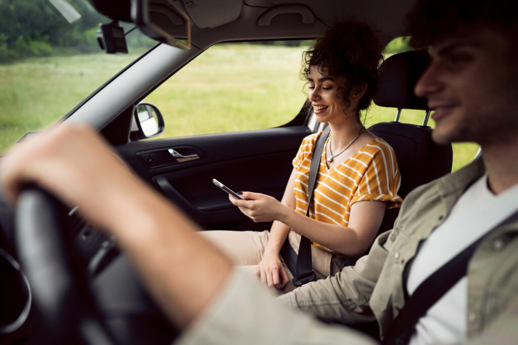 Cheerful young Caucasian couple using their smart phone.