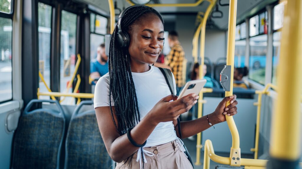 African American woman using smartphone while riding a bus