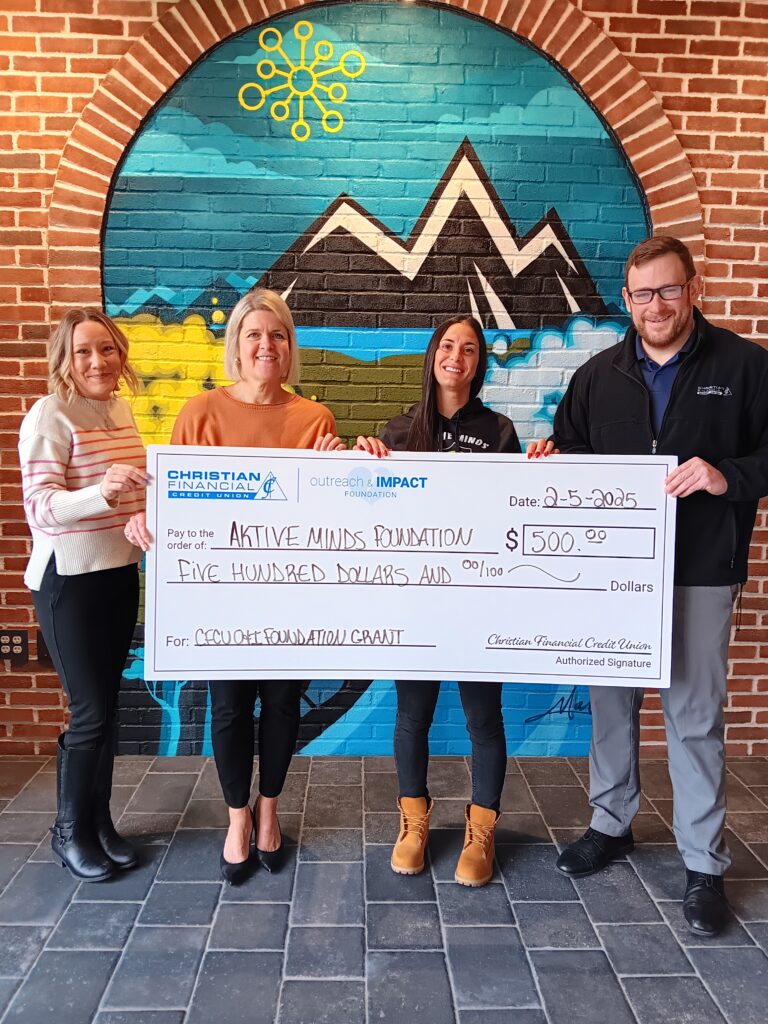 Check presentation in front of mural