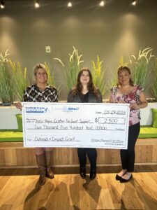 Women smiling during a check presentation to New Hope Center for Grief Support