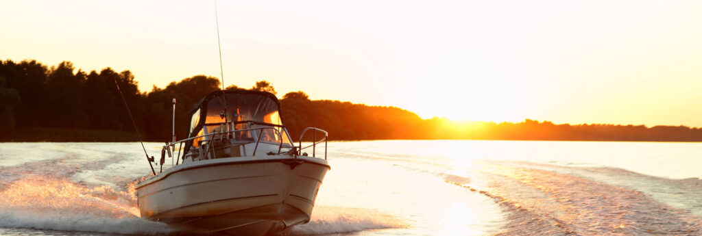Boat motoring through open water at sunset