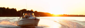 Boat motoring through open water at sunset